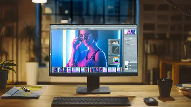 Depositphotos - Girato di un computer desktop nell'ufficio moderno con monitor che mostra il software di editing di foto